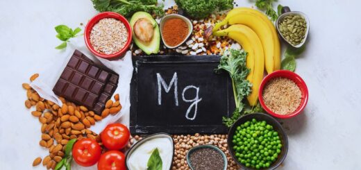 Produkty bogate w magnez ułożone wokół tabliczki z symbolem Mg, m.in. pestki, orzechy, kakao, płatki owsiane, kasza i zielone warzywa.
